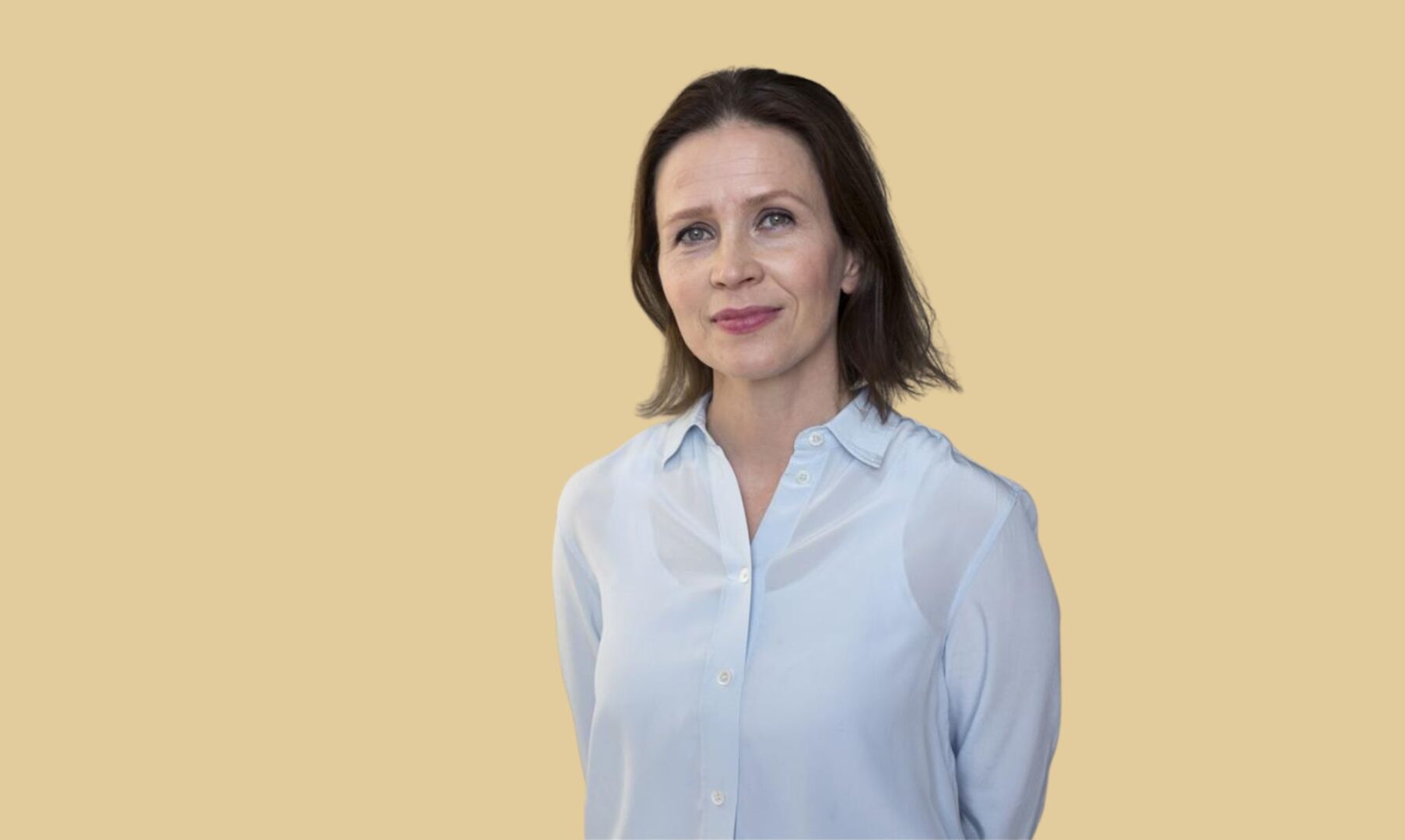 Johanna Vesikallio hiekanväristä taustaa vasten.