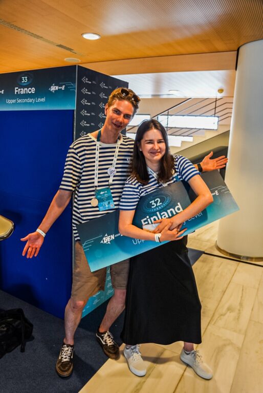 Kaksi nuorta pitää isoa kylttiä ja poseeraa.