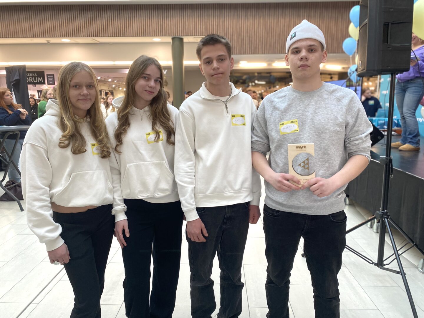 Neljä nuorta seisoo rivissä ja yhdellä on käsissään palkintopokaali.