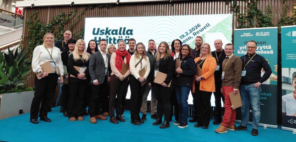 Joukko henkilöitä seisoo rivissä lavalla.