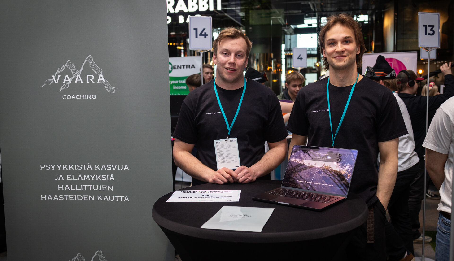 Kaksi nuorta esittelee NYT-yritystään messupisteellä.